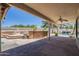 Inviting covered patio with an outdoor kitchen, overlooking a sparkling pool with a rock waterfall feature at 9412 S Palm Dr, Tempe, AZ 85284