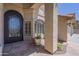 Close up of the front door with unique iron design, side windows, and stucco columns at 9412 S Palm Dr, Tempe, AZ 85284