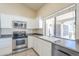 Bright kitchen features stainless appliances, white cabinets, and backyard view at 9412 S Palm Dr, Tempe, AZ 85284