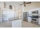 Bright kitchen features white cabinets, stainless appliances, island, and built-in desk at 9412 S Palm Dr, Tempe, AZ 85284