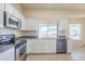 Bright kitchen features stainless appliances, white cabinets, and a large sink at 9412 S Palm Dr, Tempe, AZ 85284