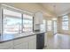 Bright kitchen features white cabinets, stainless dishwasher and a large window with views of backyard at 9412 S Palm Dr, Tempe, AZ 85284