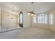 Spacious living room featuring large arched windows with plantation shutters and elegant lighting fixtures at 9412 S Palm Dr, Tempe, AZ 85284
