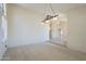 Open-plan living room with views through the hallway, carpet flooring, and pendant lighting at 9412 S Palm Dr, Tempe, AZ 85284