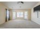 Living room with large windows, ceiling fan, and wall-mounted television at 9412 S Palm Dr, Tempe, AZ 85284