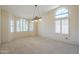 Bright living room featuring arched windows with plantation shutters and an elegant pendant light at 9412 S Palm Dr, Tempe, AZ 85284