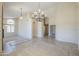 Spacious living area with carpet and tile flooring, a decorative chandelier, and an archway to the kitchen at 9412 S Palm Dr, Tempe, AZ 85284