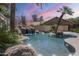 Backyard pool with rock waterfall feature and lush desert landscaping for a relaxing outdoor oasis at 9412 S Palm Dr, Tempe, AZ 85284