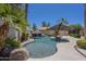 Backyard pool oasis featuring a rock waterfall, mature palm trees, and stone accents at 9412 S Palm Dr, Tempe, AZ 85284