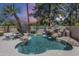 Outdoor pool with a beautiful rock waterfall feature, surrounded by lush tropical landscaping at 9412 S Palm Dr, Tempe, AZ 85284