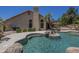 Gorgeous backyard pool featuring a rock waterfall and an adjacent covered patio at 9412 S Palm Dr, Tempe, AZ 85284