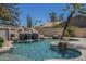 Swimming pool features a stunning rock waterfall, mature cacti, and palm trees at 9412 S Palm Dr, Tempe, AZ 85284