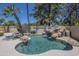 Inviting backyard pool with a rock waterfall feature and lush landscaping at 9412 S Palm Dr, Tempe, AZ 85284
