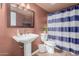 Bathroom featuring a pedestal sink, toilet, and a blue and white striped shower curtain at 1133 N 84Th Pl, Scottsdale, AZ 85257