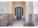 Charming home entrance with a decorative teal door framed by stone pillars and desert landscaping at 1145 E Winchester Pl, Chandler, AZ 85286