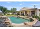 Sparkling pool in a private backyard oasis, complete with lush landscaping and rock waterfall features at 1145 E Winchester Pl, Chandler, AZ 85286
