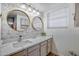 Elegant bathroom featuring double vanity, quartz countertop, round mirrors and decorative wall paper at 1211 N Miller Rd # 257, Scottsdale, AZ 85257