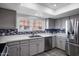 Modern kitchen with granite countertops, grey cabinets, stainless steel appliances and subway tile backsplash at 1211 N Miller Rd # 257, Scottsdale, AZ 85257
