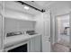 Convenient laundry room features modern washer and dryer, storage, and white sliding door at 1211 N Miller Rd # 257, Scottsdale, AZ 85257