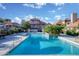 Community pool surrounded by lounge chairs and umbrellas with lush landscaping in a relaxing, resort-style setting at 1211 N Miller Rd # 257, Scottsdale, AZ 85257