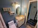 Neat bathroom featuring a vanity with granite countertop, a framed mirror, and blue walls at 1222 W Baseline Rd # 163, Tempe, AZ 85283