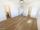 Bright bedroom with light walls, wood-look flooring and access to an ensuite bathroom and closet at 13106 W Calavar Rd, Surprise, AZ 85379