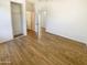 A bright bedroom with light walls, wood-look flooring and views of the closet and hallway at 13106 W Calavar Rd, Surprise, AZ 85379