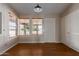 Bright, empty room with hardwood floors, two windows, and a door at 137 W Wagoner Rd, Phoenix, AZ 85023
