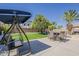Spacious backyard featuring a shaded swing, outdoor dining set, and lush lawn at 1441 E Folley Pl, Chandler, AZ 85225