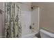 Bathroom featuring a shower-tub combination with sleek white tile and a floral shower curtain at 1441 E Folley Pl, Chandler, AZ 85225