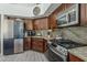 Kitchen with stainless steel appliances, dark wood cabinets, and granite countertops at 1441 E Folley Pl, Chandler, AZ 85225