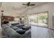 Bright living room with modern gray sofa, hardwood floors, and sliding glass doors to backyard at 1441 E Folley Pl, Chandler, AZ 85225