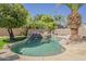 Relaxing backyard pool with a stone waterfall feature and mature trees at 1441 E Folley Pl, Chandler, AZ 85225