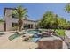 Beautiful backyard pool area with a rock waterfall feature, spa, and mature palm trees at 1441 E Folley Pl, Chandler, AZ 85225