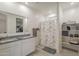 Bright bathroom featuring a dual sink vanity, a shower with a decorative curtain, and open shelving for storage at 1560 E Squire Dr, Casa Grande, AZ 85122