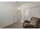 Bedroom with a comfortable recliner, ceiling fan and carpet, featuring closet with sliding doors at 1560 E Squire Dr, Casa Grande, AZ 85122