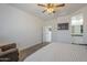 This bedroom features a ceiling fan, modern painting, and ensuite bathroom access promoting relaxation at 1560 E Squire Dr, Casa Grande, AZ 85122