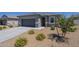 View of the inviting single-story home, with a two-car garage and desert landscaping at 1560 E Squire Dr, Casa Grande, AZ 85122