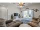 Open-concept living room features a sliding glass door, ceiling fan, and white entertainment center with sliding doors at 1560 E Squire Dr, Casa Grande, AZ 85122