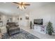 Open-concept living room with kitchen view, ceiling fan, and entertainment center with sliding doors at 1560 E Squire Dr, Casa Grande, AZ 85122