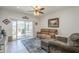 Cozy living room with a plush sofa, ceiling fan, and sliding glass door access to the backyard patio at 1560 E Squire Dr, Casa Grande, AZ 85122