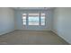 Bright bedroom featuring three large windows offering ample natural light and neighborhood views at 16777 W Sheila Ln, Goodyear, AZ 85395