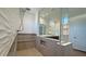 Luxurious shower with sleek design, featuring a built-in bench, textured tile and glass door at 16777 W Sheila Ln, Goodyear, AZ 85395