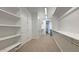 Well-organized walk-in closet featuring multiple shelves and ample storage space, and neutral carpet at 16777 W Sheila Ln, Goodyear, AZ 85395