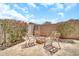Backyard area showcasing a fire pit, chairs, flower bushes, and block wall at 16917 W Sonora St, Goodyear, AZ 85338