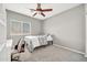 Cozy bedroom with ceiling fan, window and closet system, complete with neutral carpet and gray walls at 16917 W Sonora St, Goodyear, AZ 85338