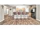 Modern kitchen featuring wood-look floors, neutral paint, a breakfast bar, stainless steel appliances, and wood cabinets at 16917 W Sonora St, Goodyear, AZ 85338