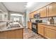 Well-equipped kitchen with wood cabinets, stainless steel appliances, and views to the dining area at 16917 W Sonora St, Goodyear, AZ 85338