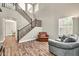 Cozy living room featuring a staircase, wood-look floors, neutral paint, and comfortable furnishings at 16917 W Sonora St, Goodyear, AZ 85338