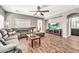 Cozy living room features wood-look floors, neutral paint, comfortable seating, ceiling fan, and ample natural light at 16917 W Sonora St, Goodyear, AZ 85338